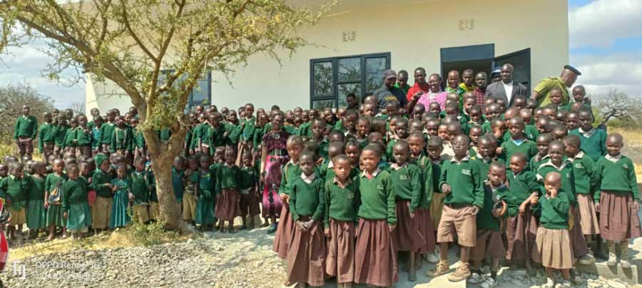 Large group of preschool students standing in front of their new school in the Arusha region of Tanzania, East Africa